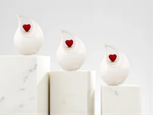 White Timeless Heart Cremation Urns on Three Marble Slabs | Elegant Memorial Tribute for Ashes