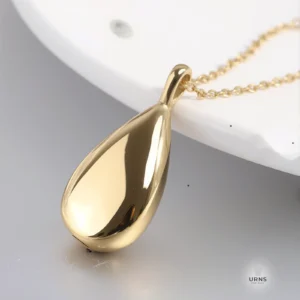 HDR enhanced image of the gold Minimalist Teardrop Urn Necklace, showing its polished, reflective finish and matching chain.