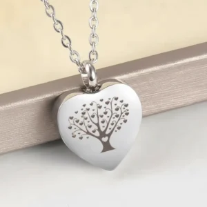 Tree of Life heart urn necklace for ashes, a stainless steel cremation jewelry pendant shown on a gift box.