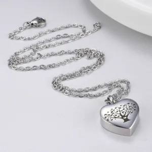 Premium HDR image of a stainless steel Tree of Life heart urn necklace with a detailed engraving, shown on a clean, light background.