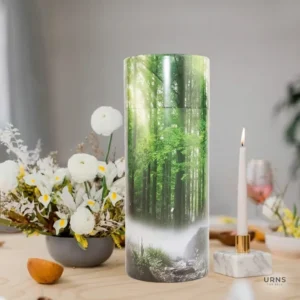 Green Forest Scattering Tube cremation container displayed on a memorial table setup with white flowers and a lighted candle, emphasizing the tube's use for home display or memorial services.