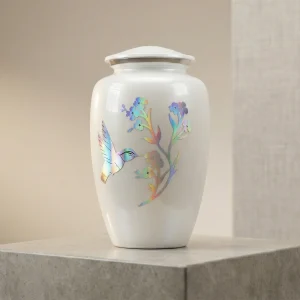Pearlescent white adult cremation urn featuring an iridescent hummingbird and flower design.