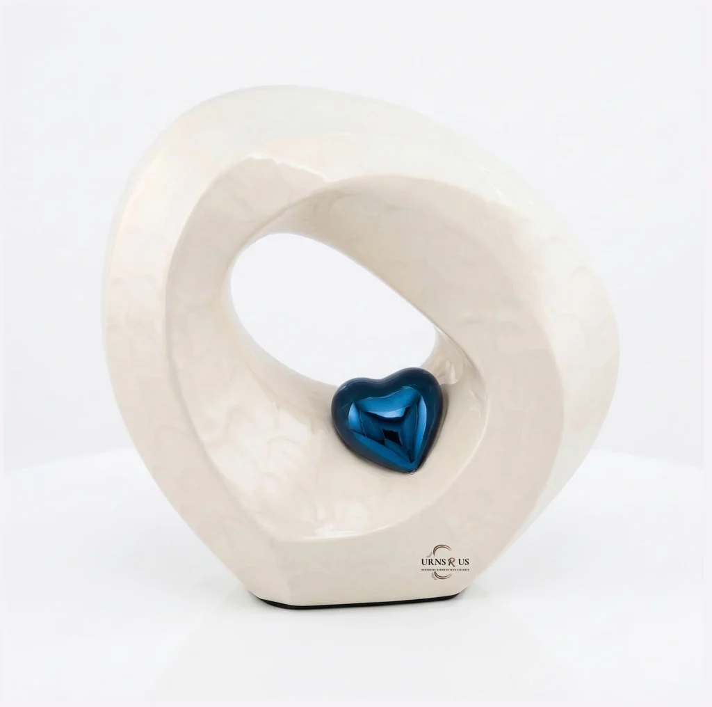 Modern white alabaster cremation urn shaped like an infinity loop with a polished sapphire blue heart in the center.