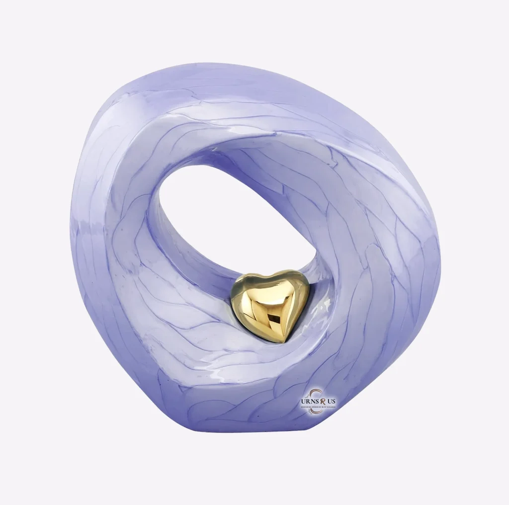 Artistic infinity loop cremation urn for ashes, featuring a sophisticated light lavender purple marbled finish and a central, polished radiant gold heart detail. Modern large adult memorial urn.