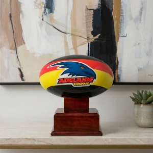 The Adelaide Crows AFL Cremation Urn displayed as a centrepiece on a modern marble console table in a bright, contemporary home living room setting.