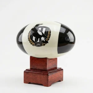 Side view of the Collingwood Magpies AFL Cremation Urn, featuring the classic black and white team emblem and resting on a polished solid timber base.