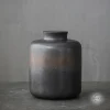 Handcrafted dark grey stoneware ceramic cremation urn for ashes featuring a textured bronze band, large 2200ml size, resting on a dark slate surface.