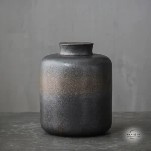 Handcrafted dark grey stoneware ceramic cremation urn for ashes featuring a textured bronze band, large 2200ml size, resting on a dark slate surface.