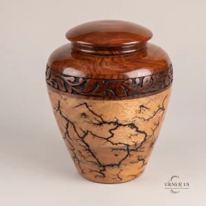 Handcrafted wooden adult cremation urn featuring dark Lichtenberg fractal burns and an intricately carved floral band, displayed at a 45-degree angle on a seamless minimalist background.