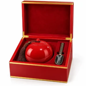 Red ceramic cremation urn for ashes inside premium wooden presentation box with decorative spoon