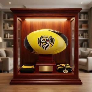 Richmond Tigers AFL memorial urn displayed in a premium trophy case alongside sports memorabilia.