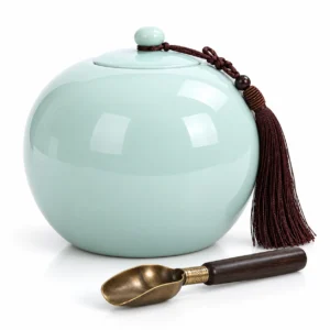 Minimalist green Serenity Sphere Ceramic Memorial Urn with a dark silk tassel on a white background.