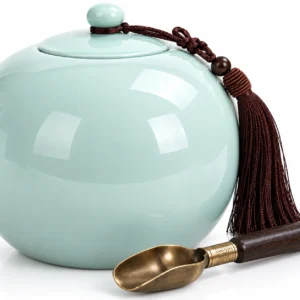 Close-up of Serenity Sphere ceramic urn lid, glossy celadon finish, tassel and brass filling scoop