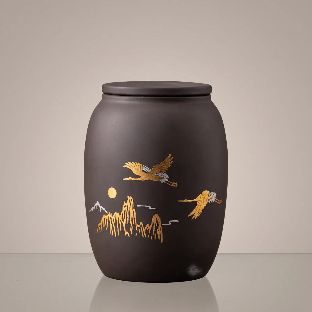 Tranquil Flight Gold Crane and Mountain ceramic keepsake cremation urn for ashes displayed on a clean studio background.