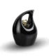 Black teardrop keepsake urn for ashes featuring a suspended small golden heart, isolated on a white background.