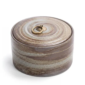 Vintage Japanese style ceramic keepsake urn for ashes, featuring a swirling brown and grey earthy glaze with a brass ring handle on the lid.