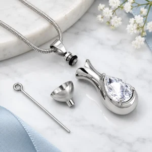 Eternal Lumière crystal ashes necklace with open urn compartment, funnel and filling tool