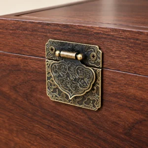 Close-up of antique-style decorative metal latch on walnut-finish wooden cremation urn