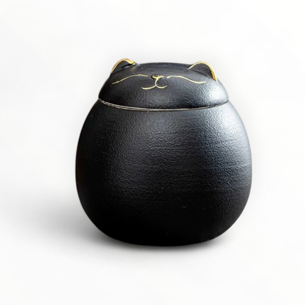 A serene black ceramic cat urn with golden details, perfect for a dignified pet memorial.