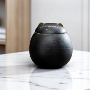 Lid detail of ceramic cat urn with engraved whiskers and gold ears