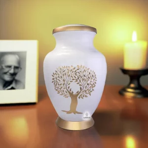 tree of life cremation urn placed on a wooden table next to a burning elegant candle